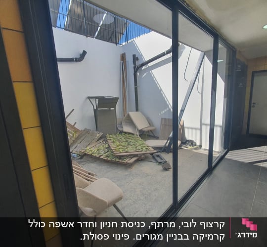 חצר עם כיסאות, קרשים, וקיר לבן